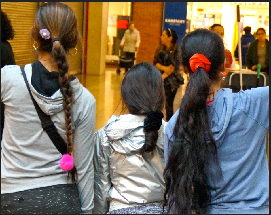 Drei Mädchen in Rückensicht im Einkaufszentrum